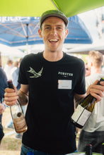 Laden Sie das Bild in den Galerie-Viewer, Johannes Forster lacht auf dem Event Rebenbeben in Wallhausen und hält zwei Weinflaschen in der Hand. 